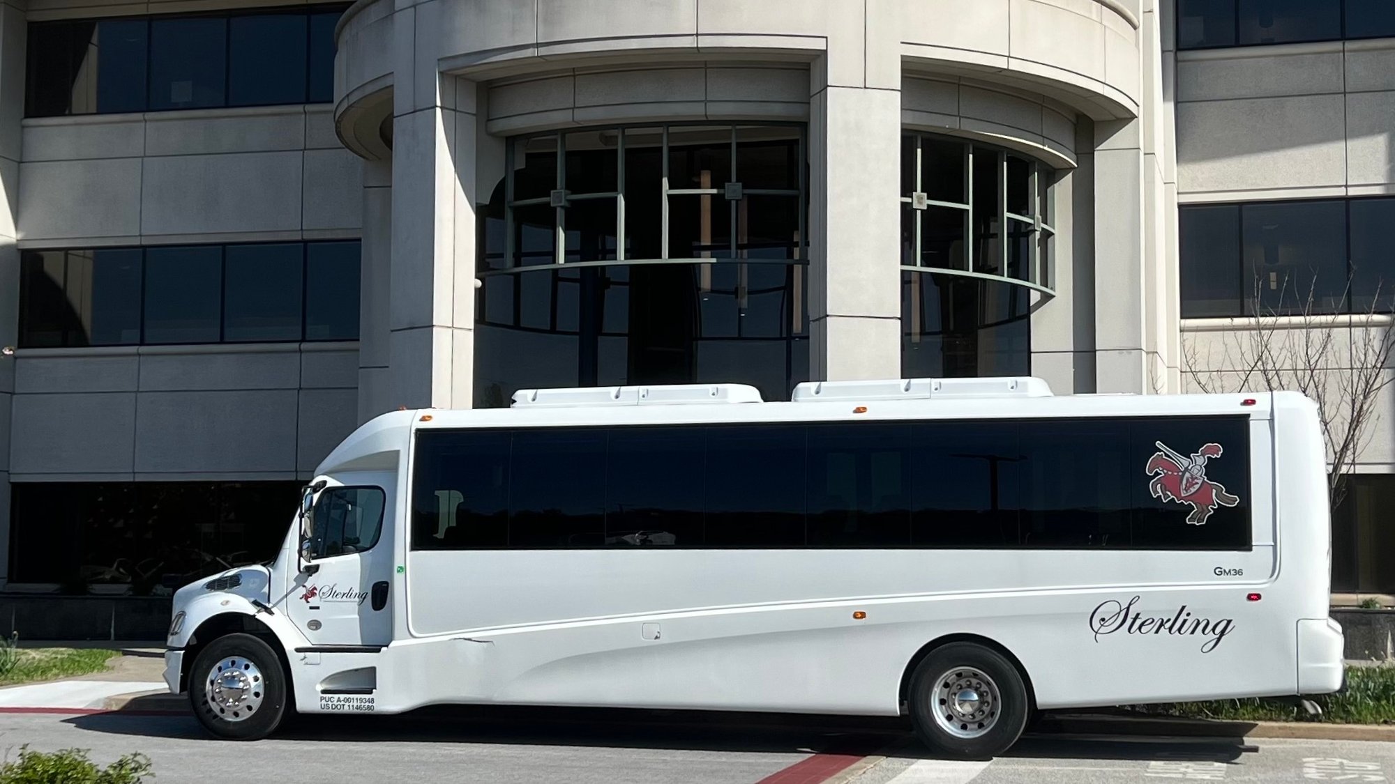 31 passenger mini bus on front of office building - day
