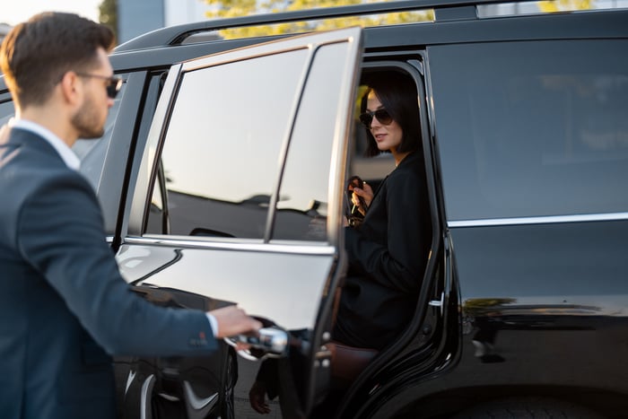 Chauffeur assisting passenger out of the car