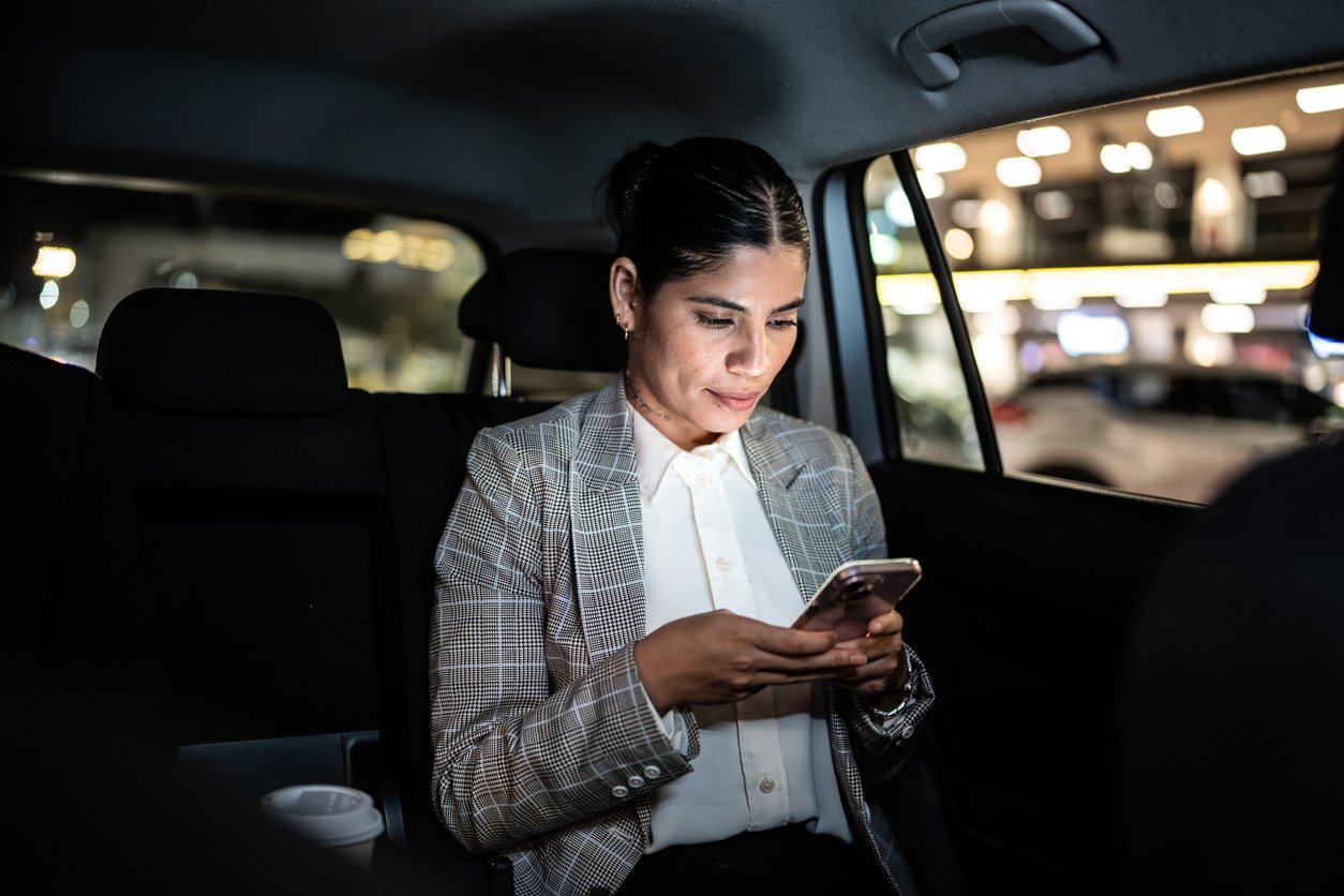 Stock female business traveler in back seat